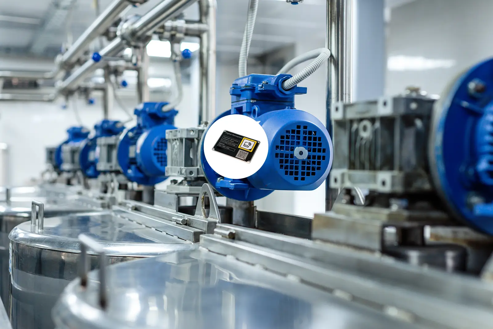 Blauer Elektromotor in einer Produktionsanlage mit elektronischem Bauteil im Vordergrund